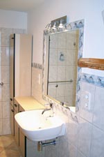 Waschbecken mit gro&szlig;em Spiegel im Badezimmer oben.